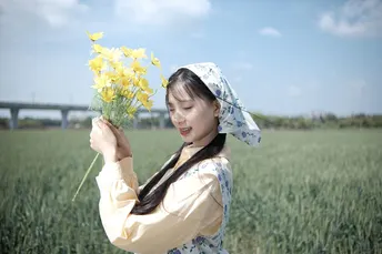 穿连衣裙的年轻女子抱着黄色花朵