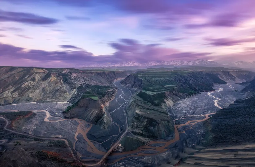 远处的山谷上有一片紫色的天空 河流穿过山谷 远处有山脉。