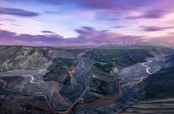 远处的山谷上有一片紫色的天空 河流穿过山谷 远处有山脉。