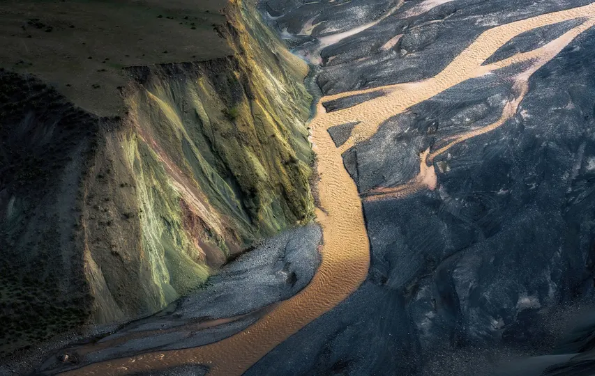 一条河流穿过了山脉和冰川之间的山谷。