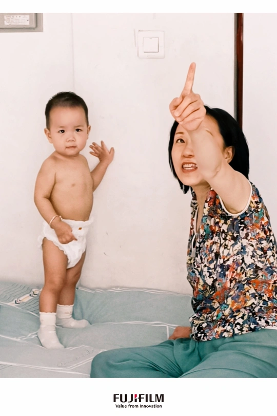 一个年轻的儿童坐在床上 女人正指着她的手指。