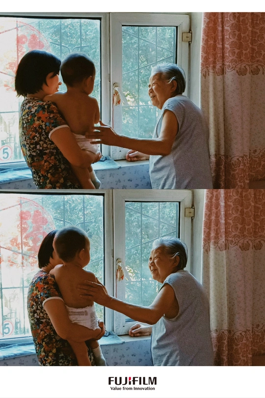 一位年长的女人在窗边喂食婴儿