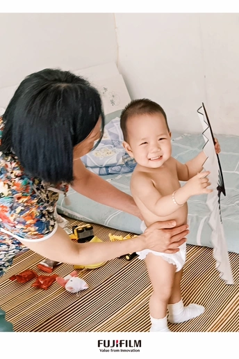 一位女子抱着婴儿坐在地板上