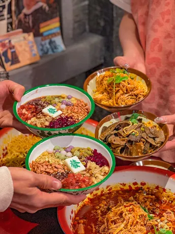 一群人拿着盘子和碗装食物