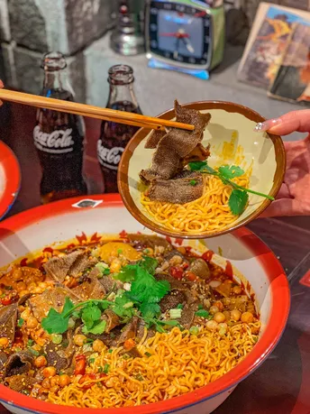 一个人用筷子在桌子上吃一碗食物