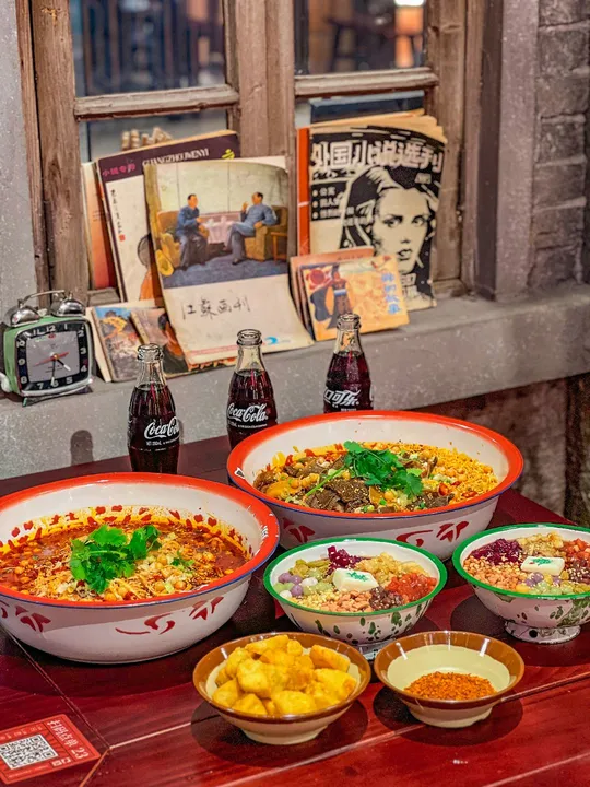 几道菜摆在一张桌子前面 前面有画。