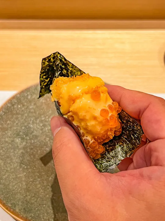 一个人用筷子夹着一个小盘子里的食物
