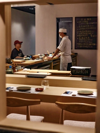 一些人正在一家餐厅工作 一个人站在柜台前准备食物。