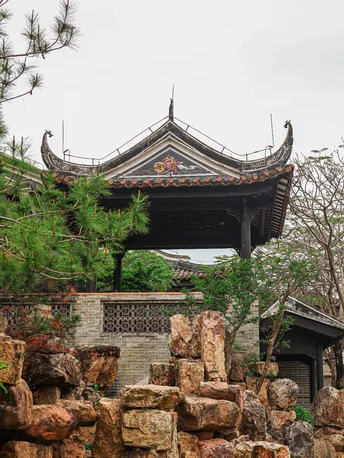 岩石围墙的花园中的一个塔和一个亭子