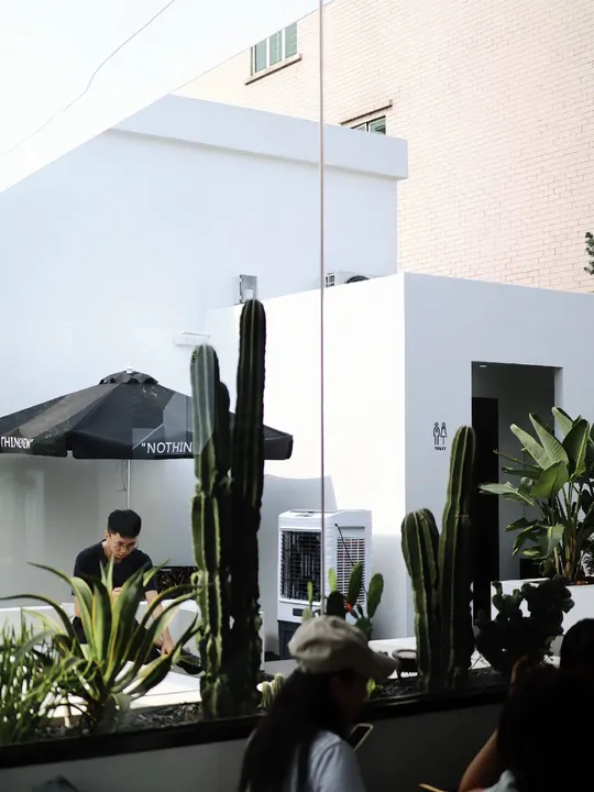 人们在白色建筑外面的院子里坐在桌子旁