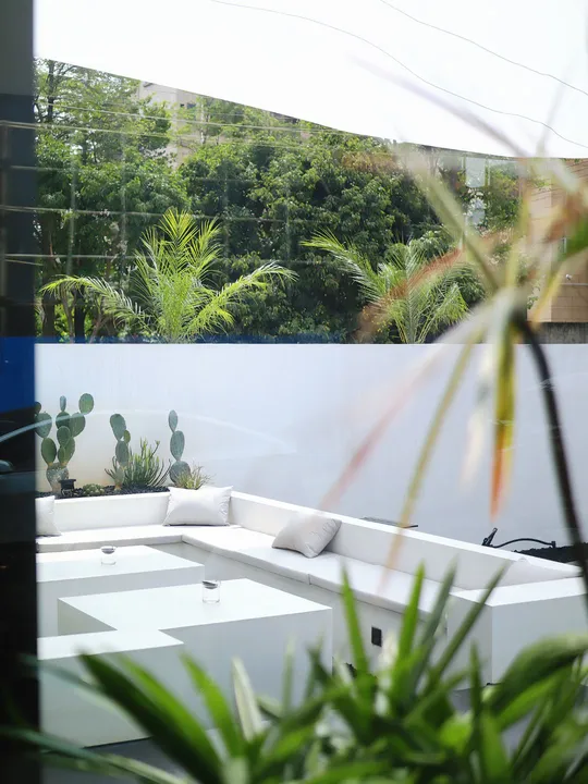 白色浴缸和桌子位于一扇俯瞰花园的大窗户前