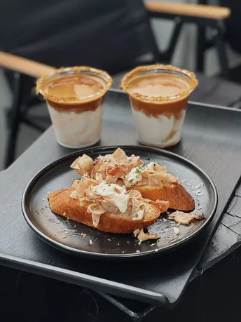 一盘食物放在一张黑色托盘上 托盘放在桌子上。