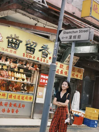 站在街上一家商店前 建筑物上有标志的年轻女子