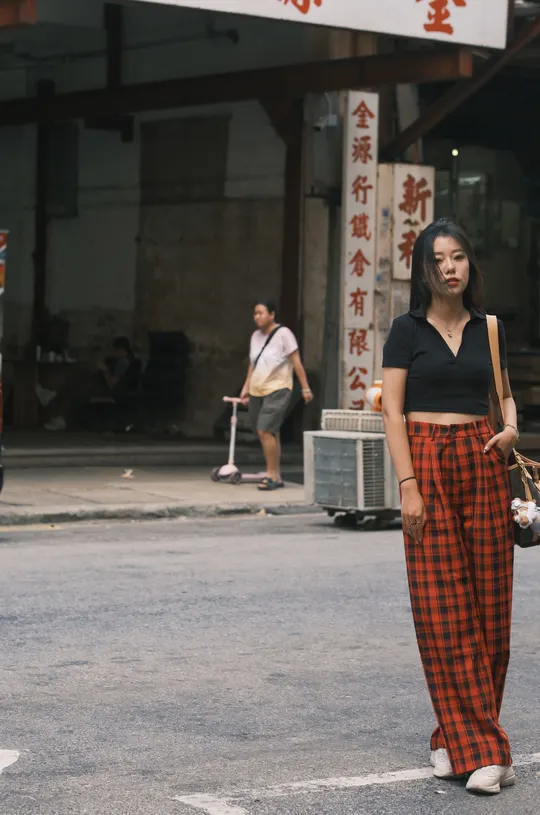 穿格子裤子的年轻女子走在街上