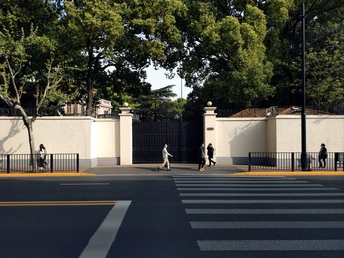 人行道上有白色的大门和人们沿着道路走