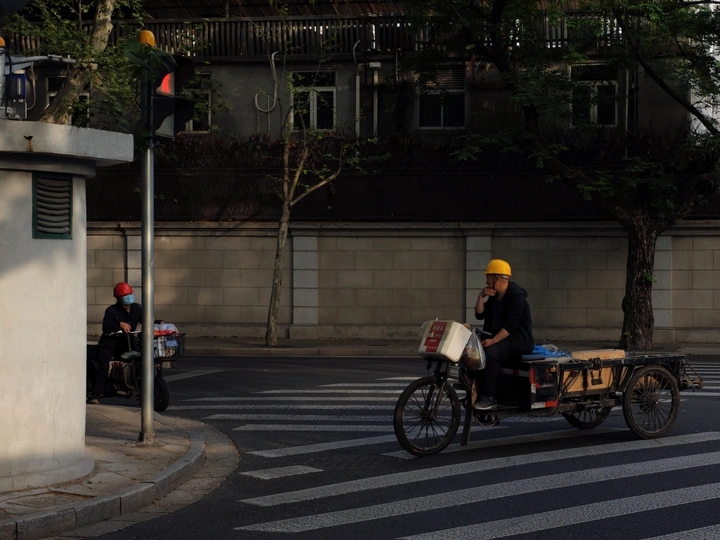 一个戴安全帽的男子骑自行车沿着街道行驶