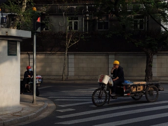 一个戴安全帽的男子骑自行车沿着街道行驶