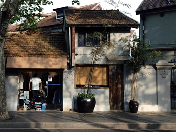 一条街道上有一栋建筑和一辆摩托车。