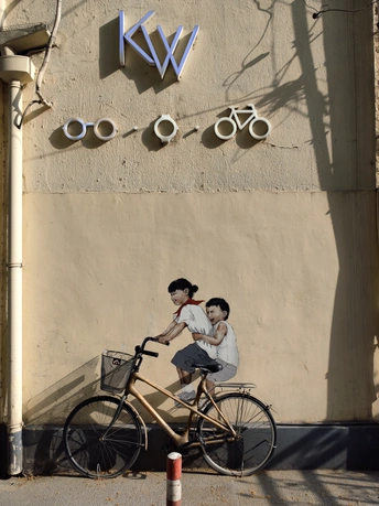 一个人骑自行车在建筑物旁边