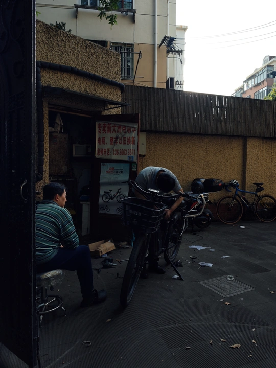 一个坐在街边与停自行车有关的建筑物的男人