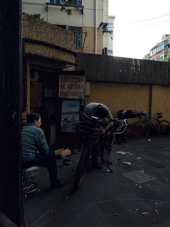 一个坐在街边与停自行车有关的建筑物的男人