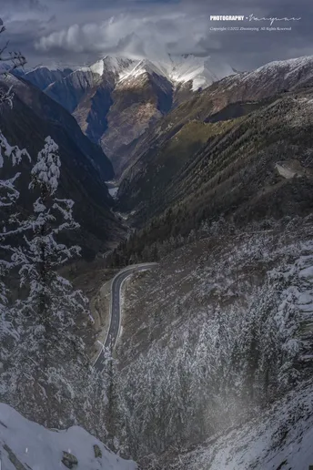 一条蜿蜒的山间小路 山上覆盖着白雪。