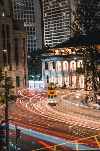 夜晚的城市街道 汽车和一辆黄色公交车沿着道路行驶 还有高大的建筑。