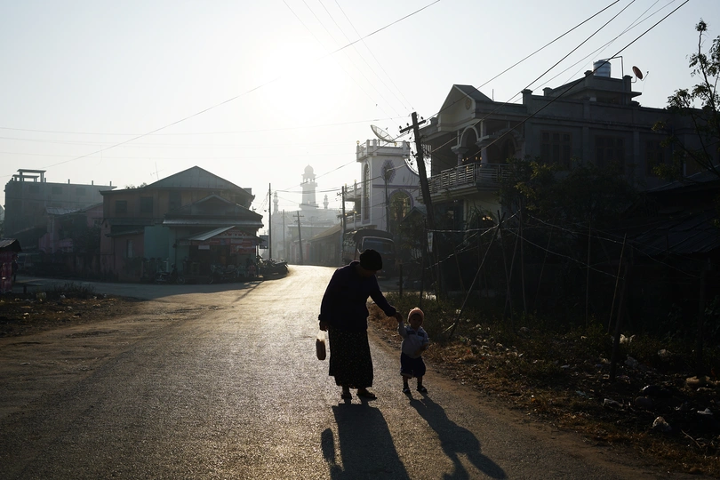 一位女子牵着一个小男孩走在街上