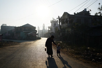 一位女子牵着一个小男孩走在街上