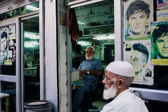 一个老人坐在理发店窗口