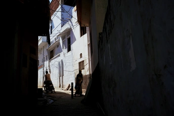 人们走在老建筑之间狭窄的巷子里