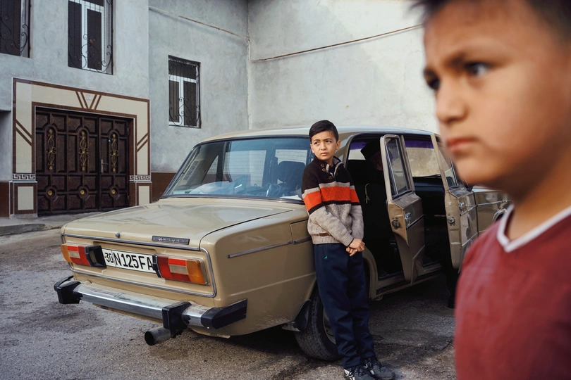 一些年轻男孩站在一辆汽车旁边