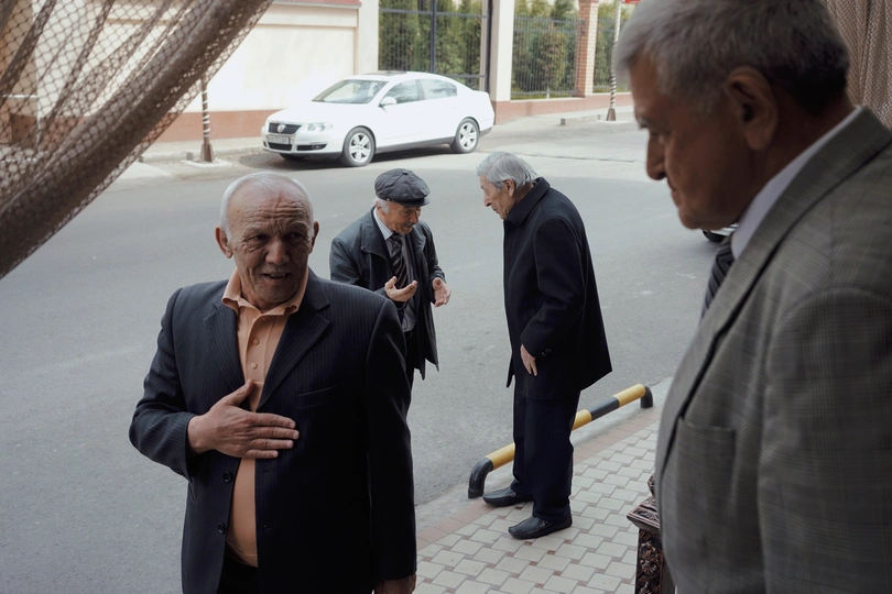 穿西装打领带的老男人站在人行道上