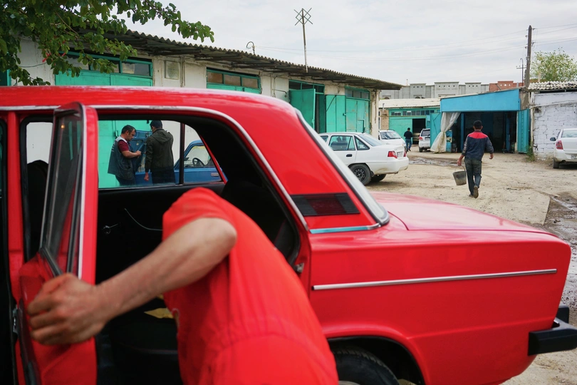 一个人把头靠在红色卡车的门上