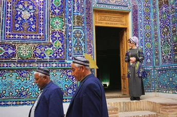 一些男人站在一栋建筑前 墙壁和门上都有彩色瓷砖。