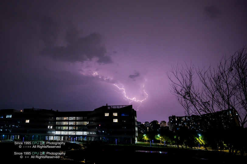 夜幕下城市上空紫色天空中的闪电