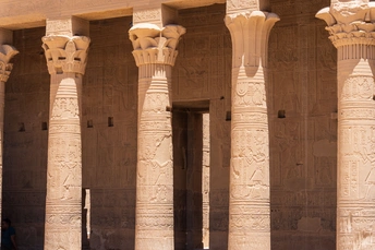 一位女士走过一座有柱子和支柱的古建筑