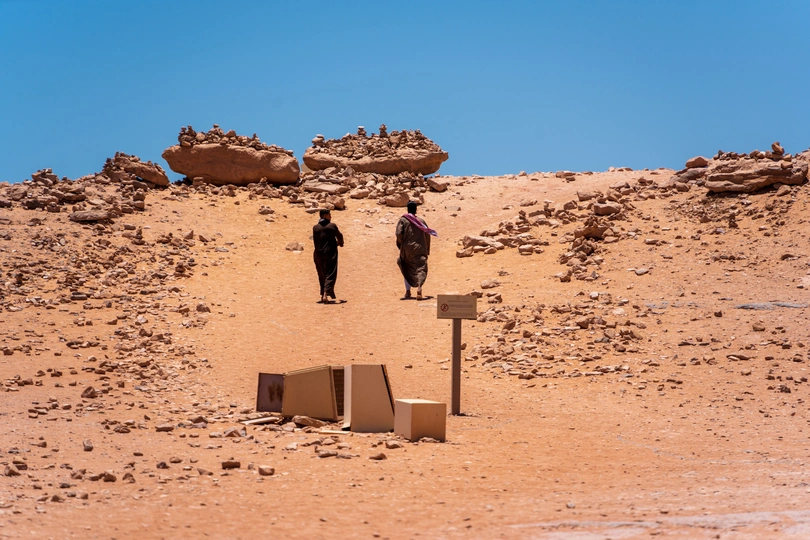 一些男人站在一个堆满岩石的小山丘上
