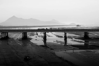 火车穿过有山丘为背景的桥