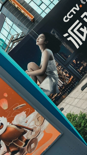 一位坐在冲浪板上的女人 前面有建筑物一侧的大广告