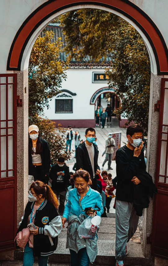 人们戴口罩走在一座城市的一条街道上