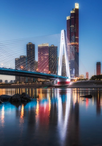 夜晚的城市 有亮起的摩天大楼和跨水大桥。