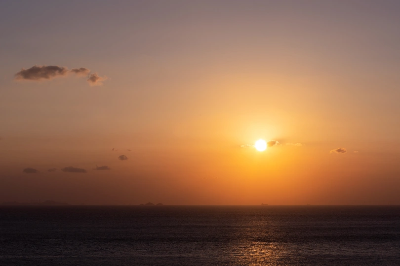 日落或日出时 在水面或海洋上 太阳在地平线上落下。
