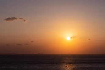 日落或日出时 在水面或海洋上 太阳在地平线上落下。