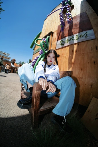 一个小女孩坐在木椅上 木椅放在木凳上
