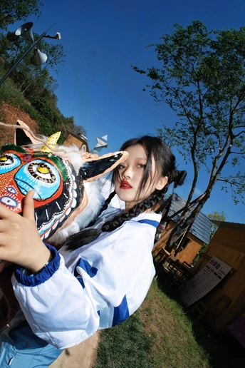 一位年轻女子举面具至脸前拍照
