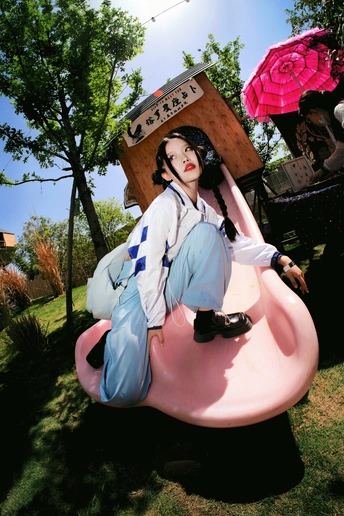 一尊穿着蓝色连衣裙骑着粉色雨伞的女人雕像