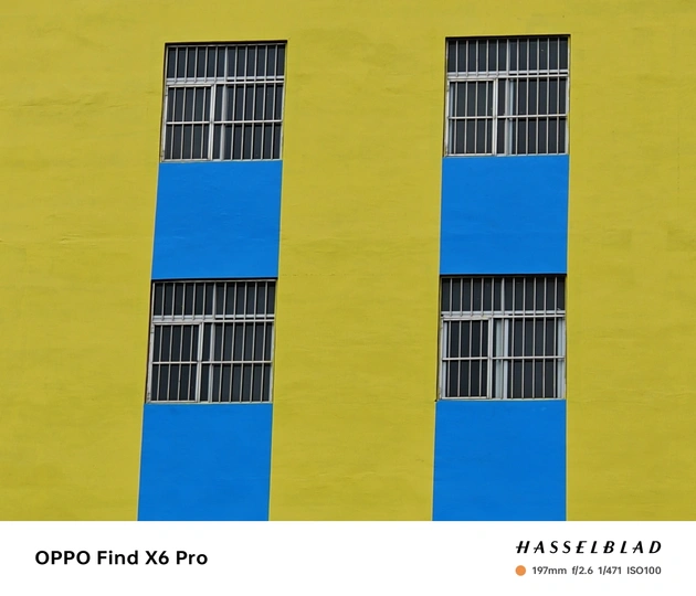 一栋建筑的多彩墙壁 有多个不同颜色的黄色和蓝色窗户。