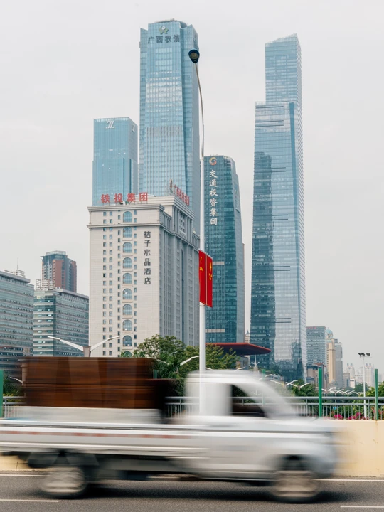 这是一个大型城市 有许多高楼大厦 一辆白色的卡车在公路上行驶。