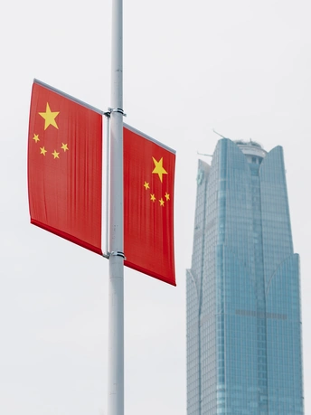 城市中高楼前挂着一条红旗